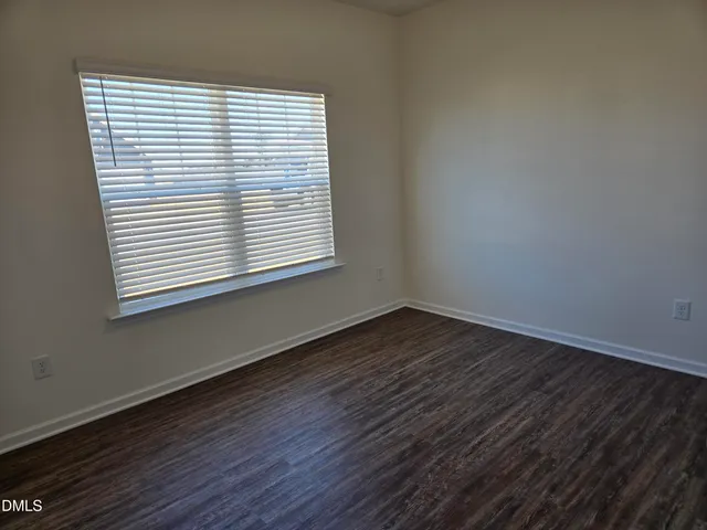 an empty room with wooden floor and a window