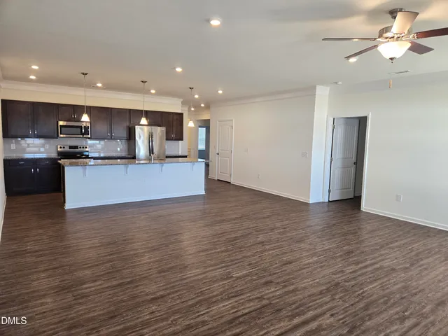 a view of kitchen with kitchen island wooden floor center island and stainless steel appliances