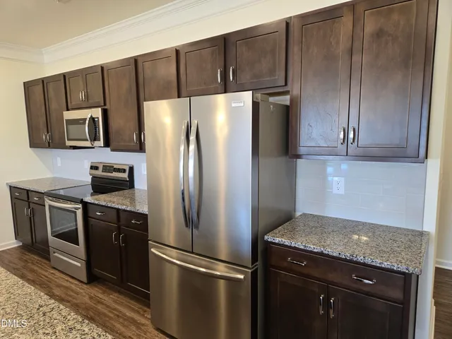 a kitchen with stainless steel appliances granite countertop a refrigerator stove and microwave