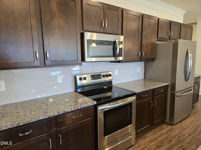 a kitchen with granite countertop wooden cabinets and stainless steel appliances