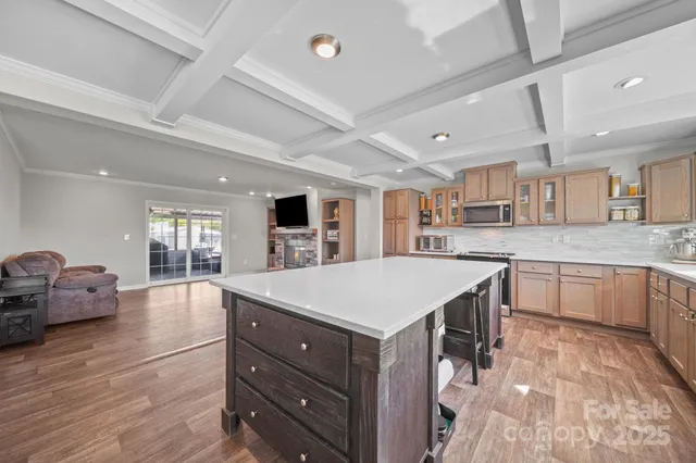 a large kitchen with a counter space a sink appliances and cabinets