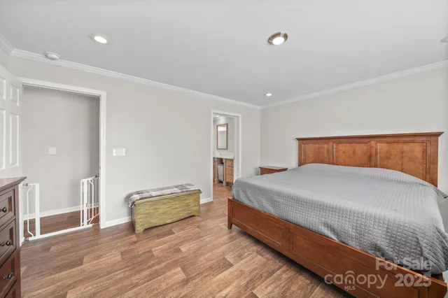 a spacious bedroom with a bed and wooden floor