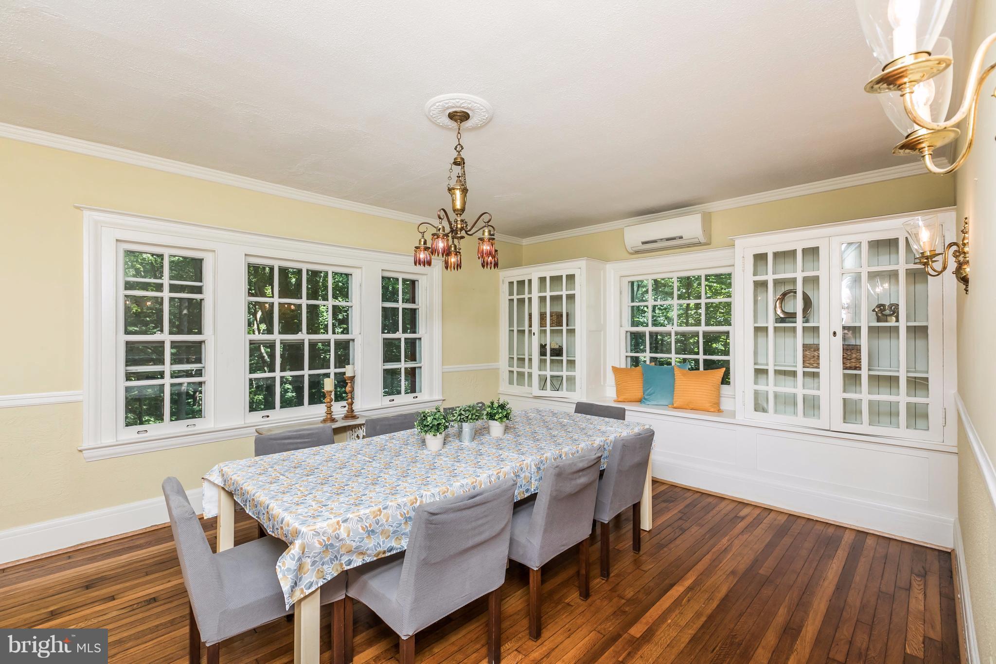 212 Longwood Road Baltimore, MD 21210 - Photo 13 of 30 a dining room with wooden floor a chandelier a wooden table and chairs