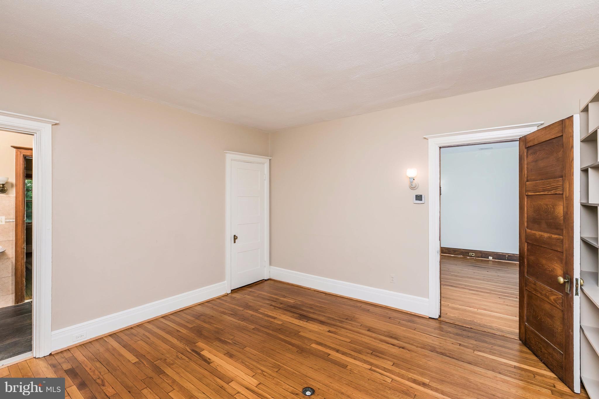 212 Longwood Road Baltimore, MD 21210 - Photo 7 of 30 a view of an empty room with wooden floor and a window