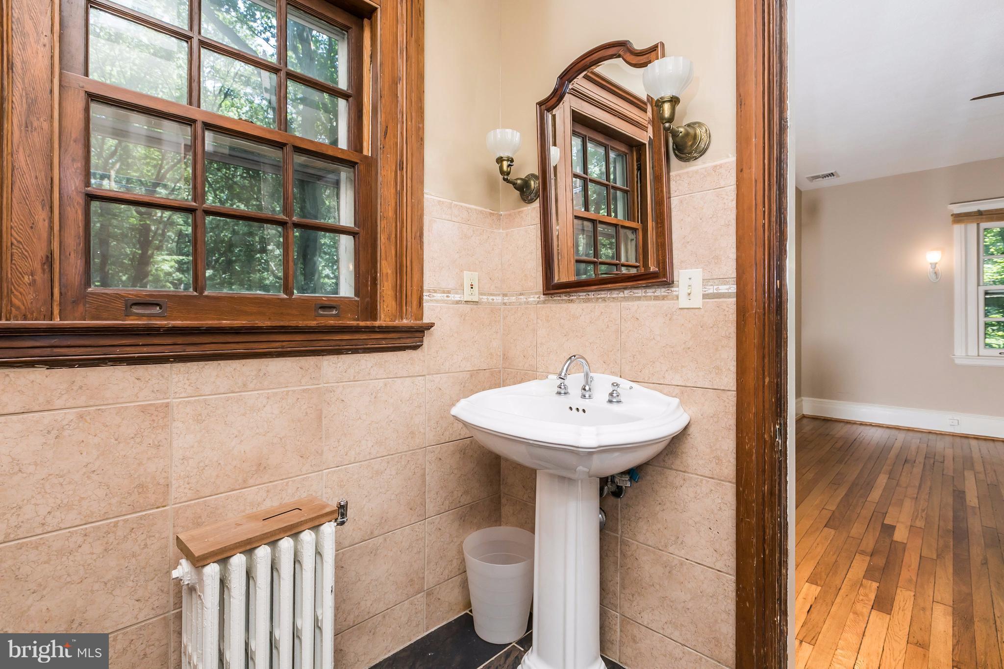 212 Longwood Road Baltimore, MD 21210 - Photo 10 of 30 a bathroom with a sink a mirror and a window