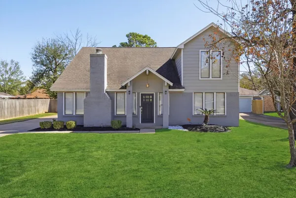 a front view of a house with a yard and trees