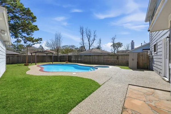 a view of a house with a big yard and large tree