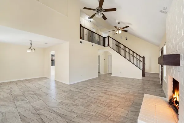 an empty room with fan and windows