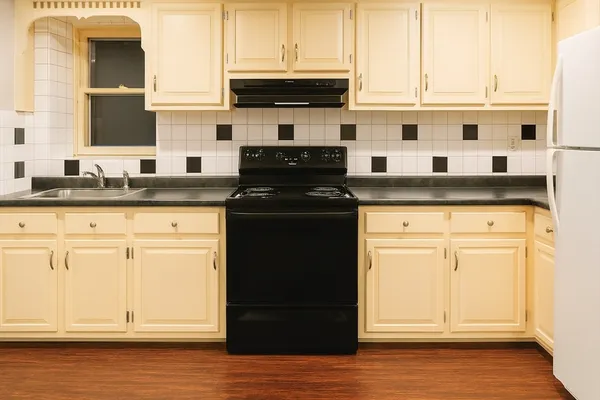 a kitchen with granite countertop white cabinets and black appliances