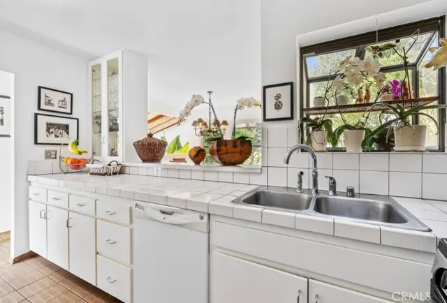 a kitchen with a sink and a painting on the wall