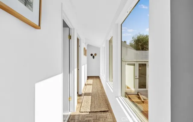 a view of a hallway with wooden floor and a living room