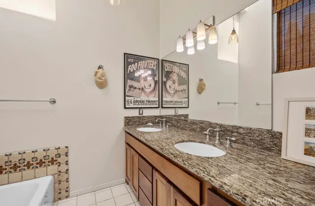 a bathroom with a granite countertop sink a mirror and a shower