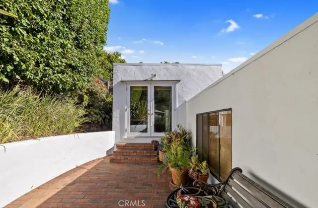 a porch with a table and chairs and potted plants