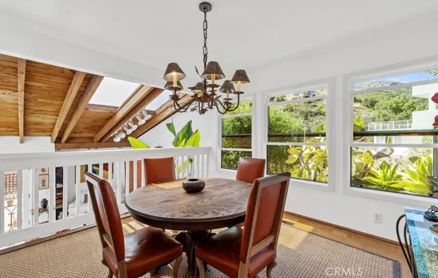 a view of a dining room with furniture a chandelier and wooden floor