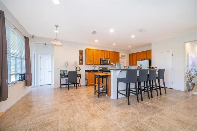 a living room with furniture and a dining table with kitchen appliances