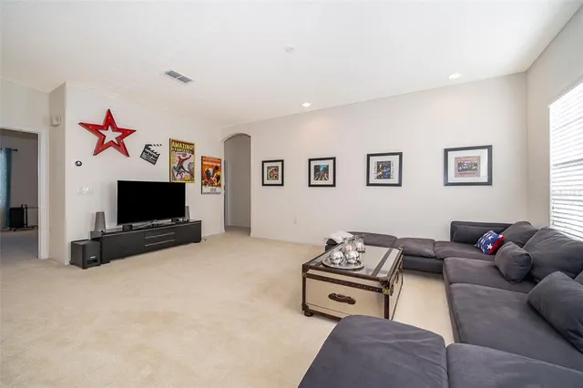 a living room with furniture flat screen tv and a window