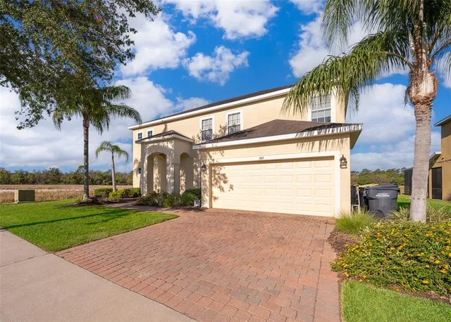 a front view of a house with a garden and trees