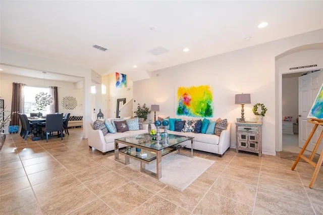 a living room with furniture kitchen view and a large window