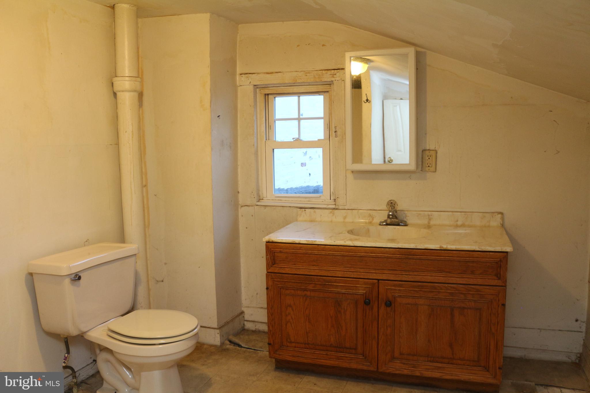 929 Washington Street Reading, PA 19601 - Photo 13 of 14 a bathroom with a granite countertop toilet sink and mirror
