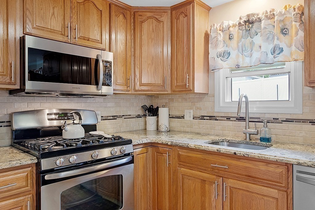 296 St Nicholas Avenue Worcester, MA 01606 - Photo 2 of 32 a kitchen with granite countertop a stove and a sink