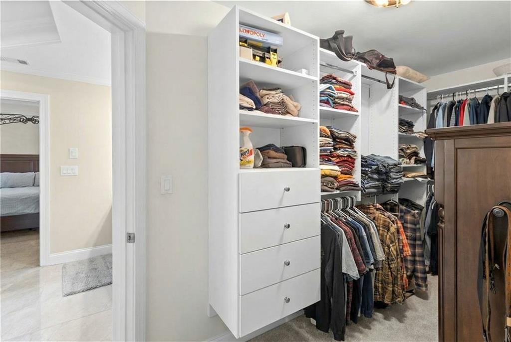 67 Pointer Lane Braselton, GA 30517 - Photo 22 of 45 a view of walk in closet with clothes and shoes
