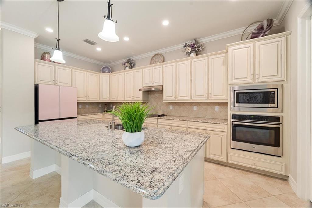 12840 Kinross Lane Naples, FL 34120 - Photo 11 of 44 a kitchen with stainless steel appliances granite countertop a sink a stove and cabinets