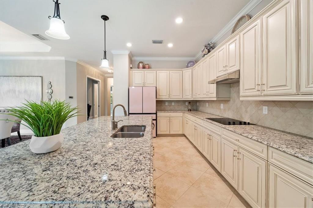 12840 Kinross Lane Naples, FL 34120 - Photo 12 of 44 a kitchen with stainless steel appliances kitchen island granite countertop a sink a granite counter tops and a view of living room