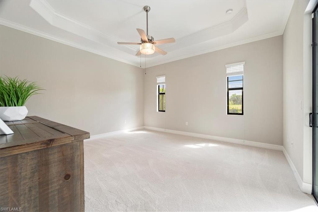 12840 Kinross Lane Naples, FL 34120 - Photo 17 of 44 en empty room with windows and ceiling fan