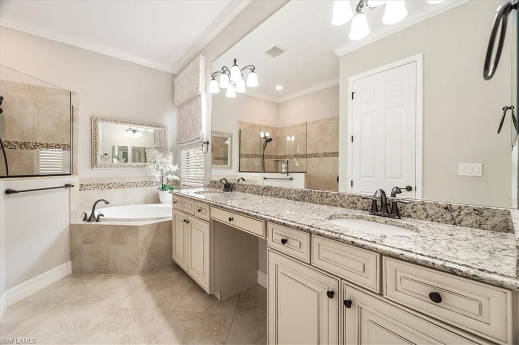 12840 Kinross Lane Naples, FL 34120 - Photo 19 of 44 a spacious bathroom with a granite countertop double vanity sink a mirror and a bathtub