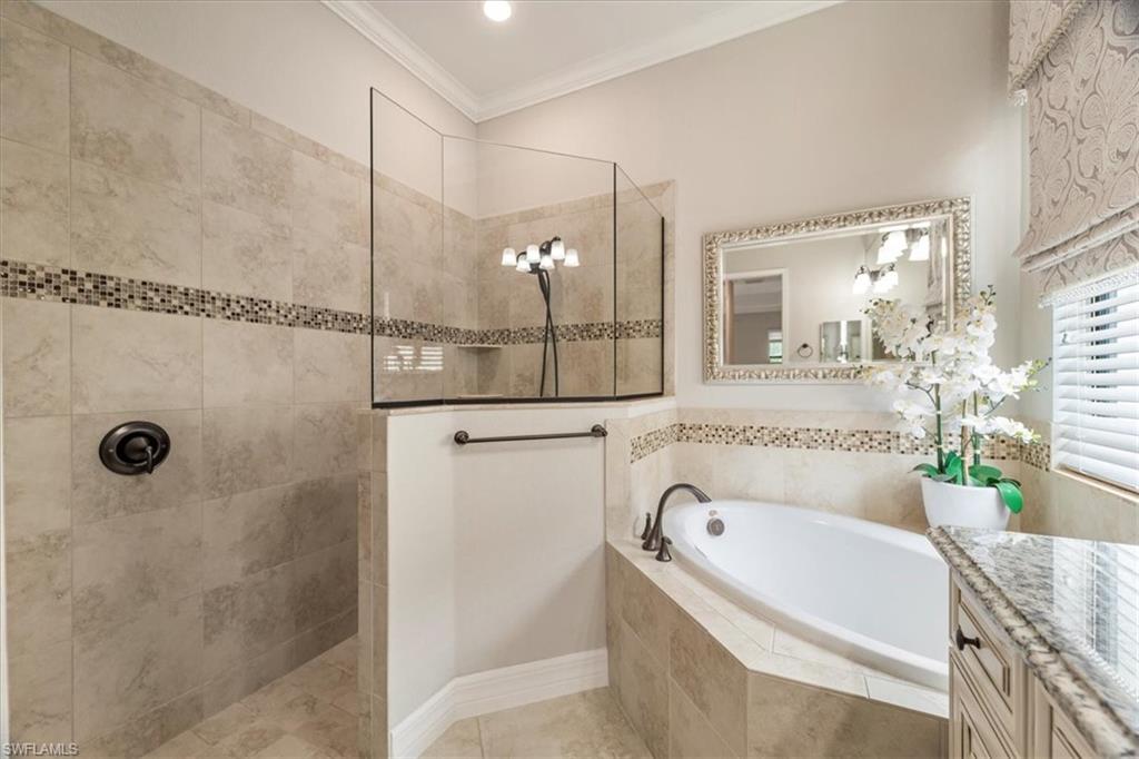12840 Kinross Lane Naples, FL 34120 - Photo 20 of 44 a bathroom with a tub a mirror and a shower