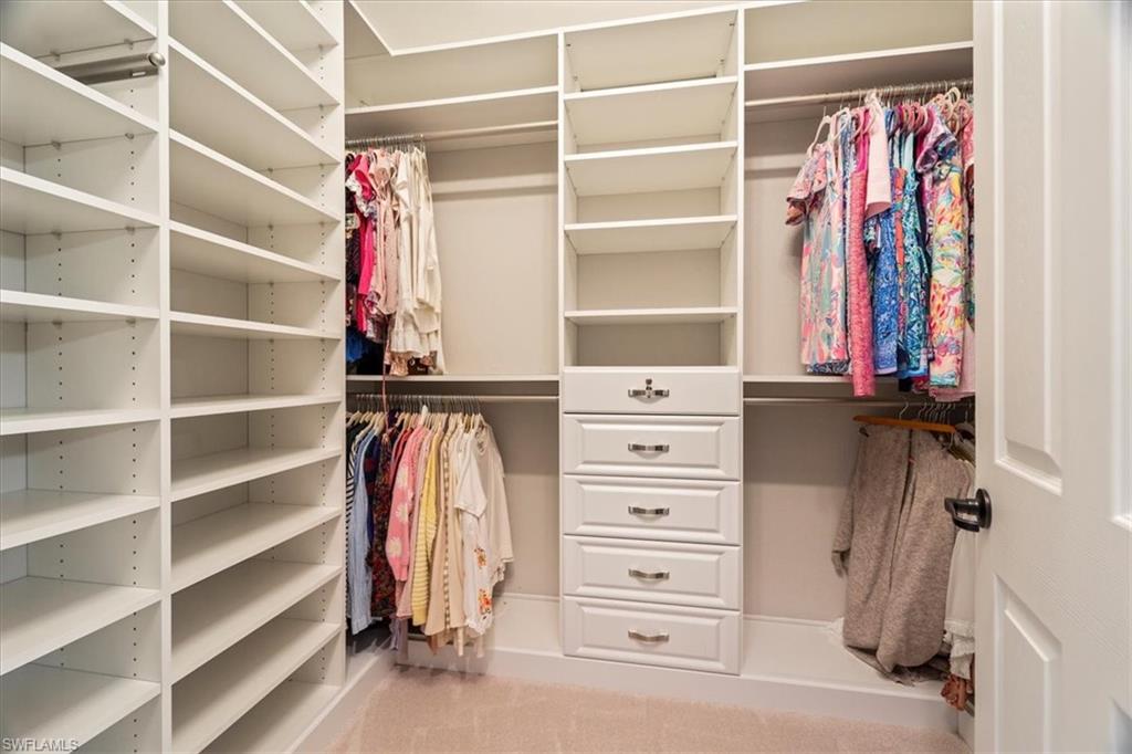 12840 Kinross Lane Naples, FL 34120 - Photo 21 of 44 a view of walk in closet with clothes and shoes