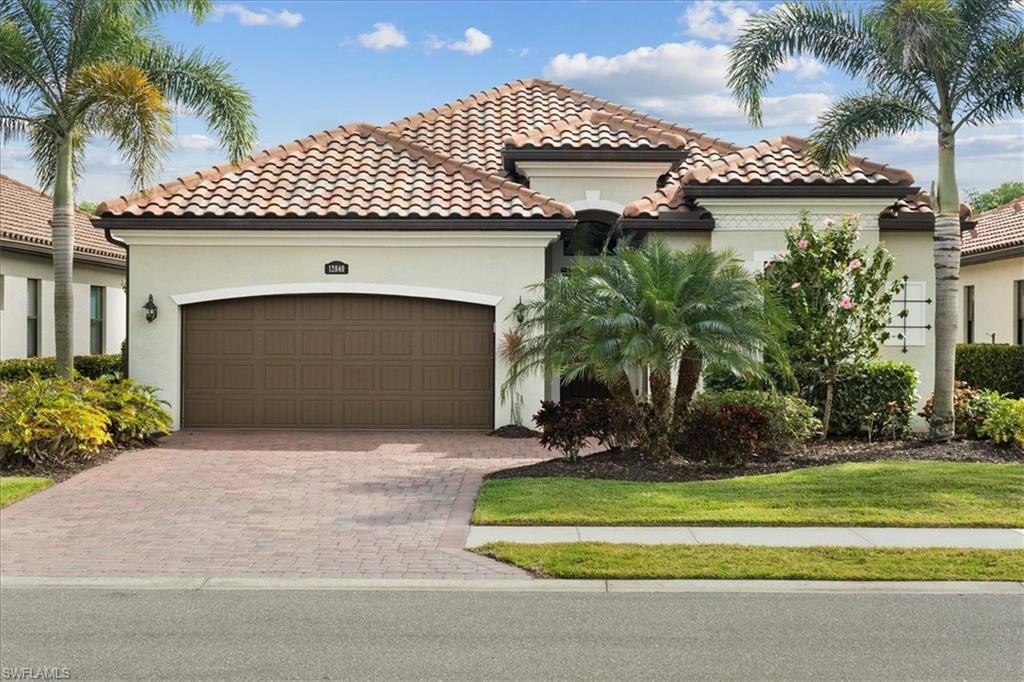 12840 Kinross Lane Naples, FL 34120 - Photo 27 of 44 a front view of a house with a yard and garage