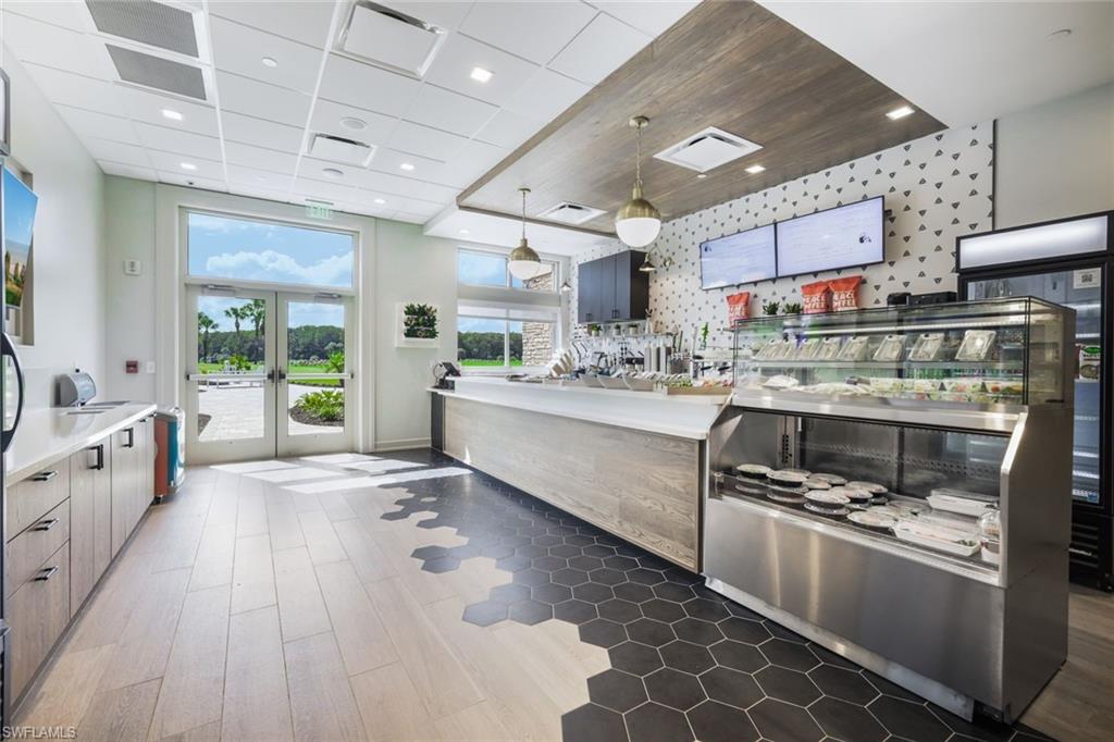 12840 Kinross Lane Naples, FL 34120 - Photo 42 of 44 a large white kitchen with a large window a sink and stainless steel appliances