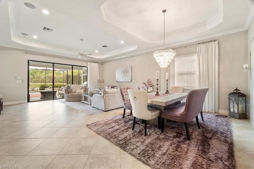 12840 Kinross Lane Naples, FL 34120 - Photo 8 of 44 a view of a dining room with furniture a chandelier and wooden floor
