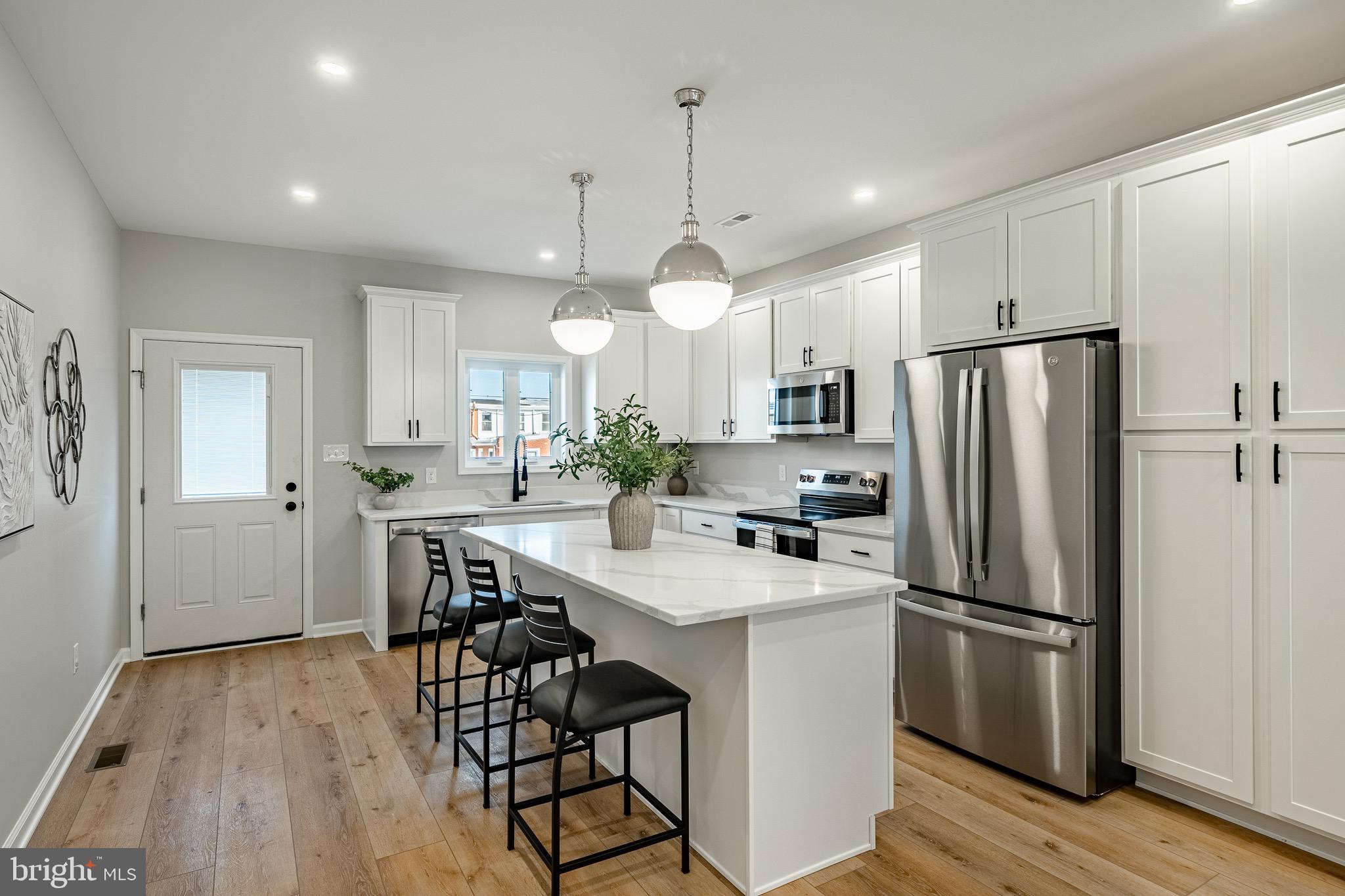 523 Grove Street Bridgeport, PA 19405 - Photo 4 of 25 a kitchen with kitchen island white cabinets and stainless steel appliances