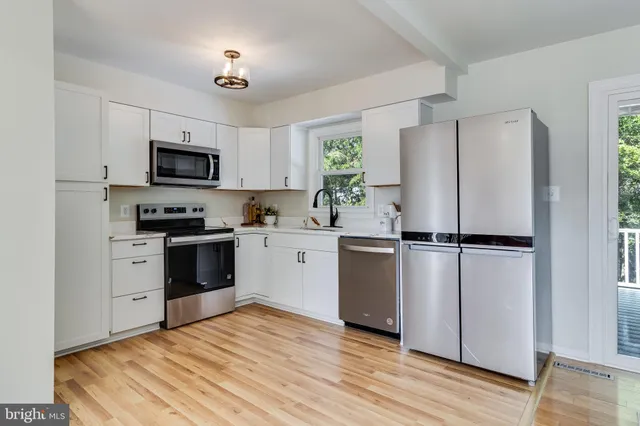 a dining room with wooden floor a chandelier a glass table and chairs