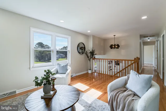 a living room with furniture potted plant and kitchen view