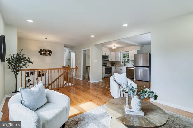 a living room with furniture a wooden floor and a kitchen view