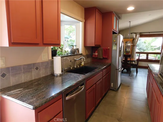 a kitchen with stainless steel appliances granite countertop a stove a sink and a refrigerator