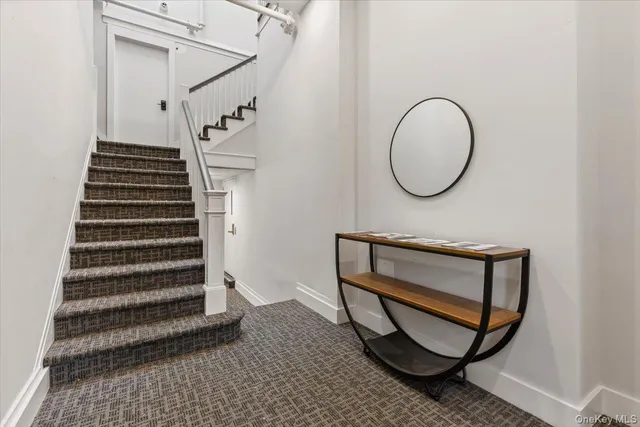 a view of a hallway with wooden floor and a potted plant