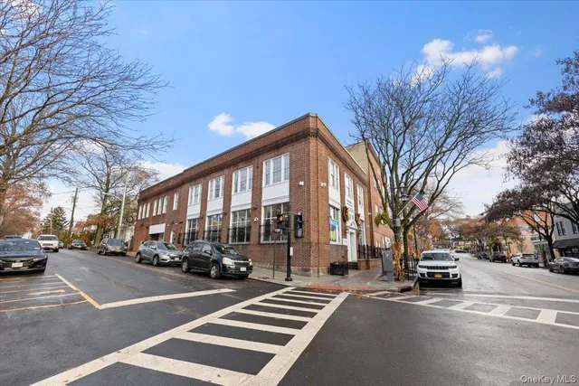 a building with trees and cars parked in front of it