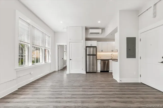 a view of a kitchen with a refrigerator a stove top oven and cabinets