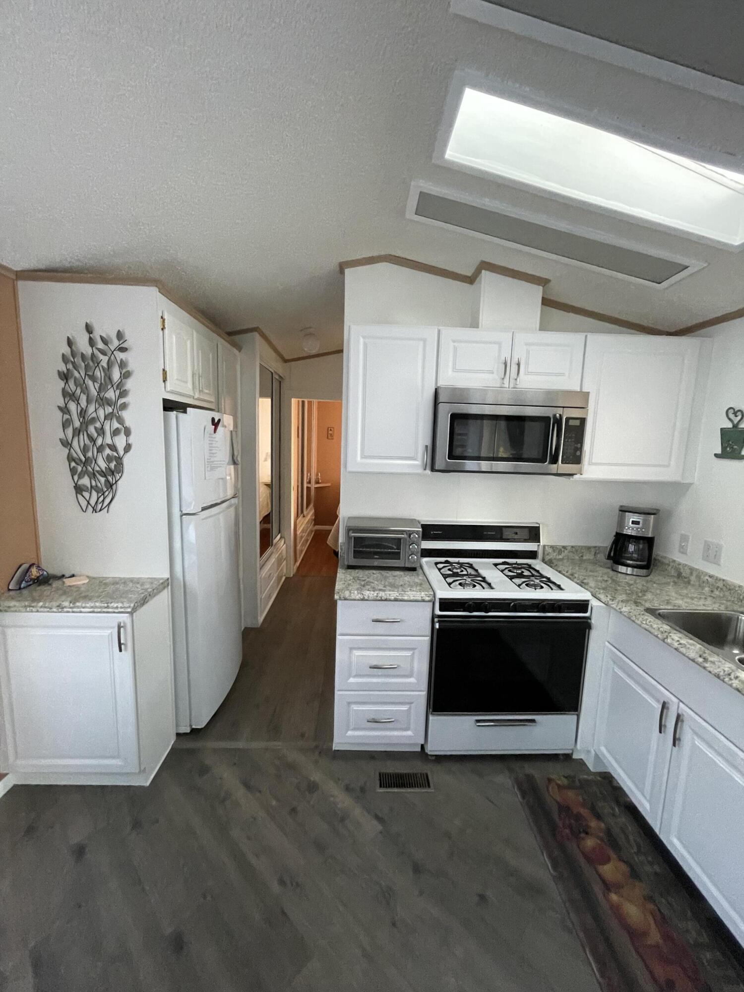 81620 Ave 49, Unit 27A Indio, CA 92201 - Photo 18 of 22 a kitchen with granite countertop a refrigerator stove and sink