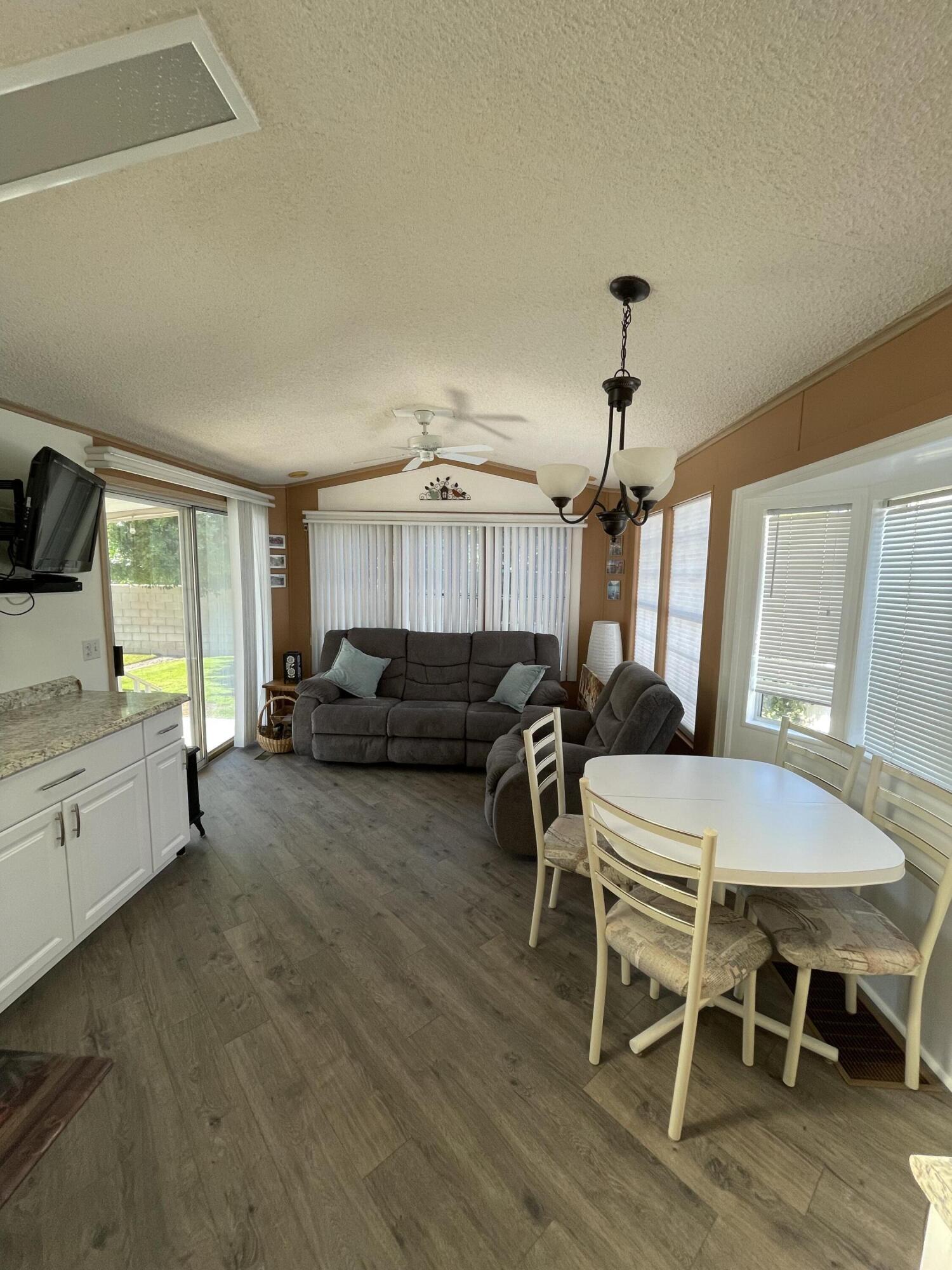 81620 Ave 49, Unit 27A Indio, CA 92201 - Photo 20 of 22 a living room with furniture a dining table and a flat screen tv
