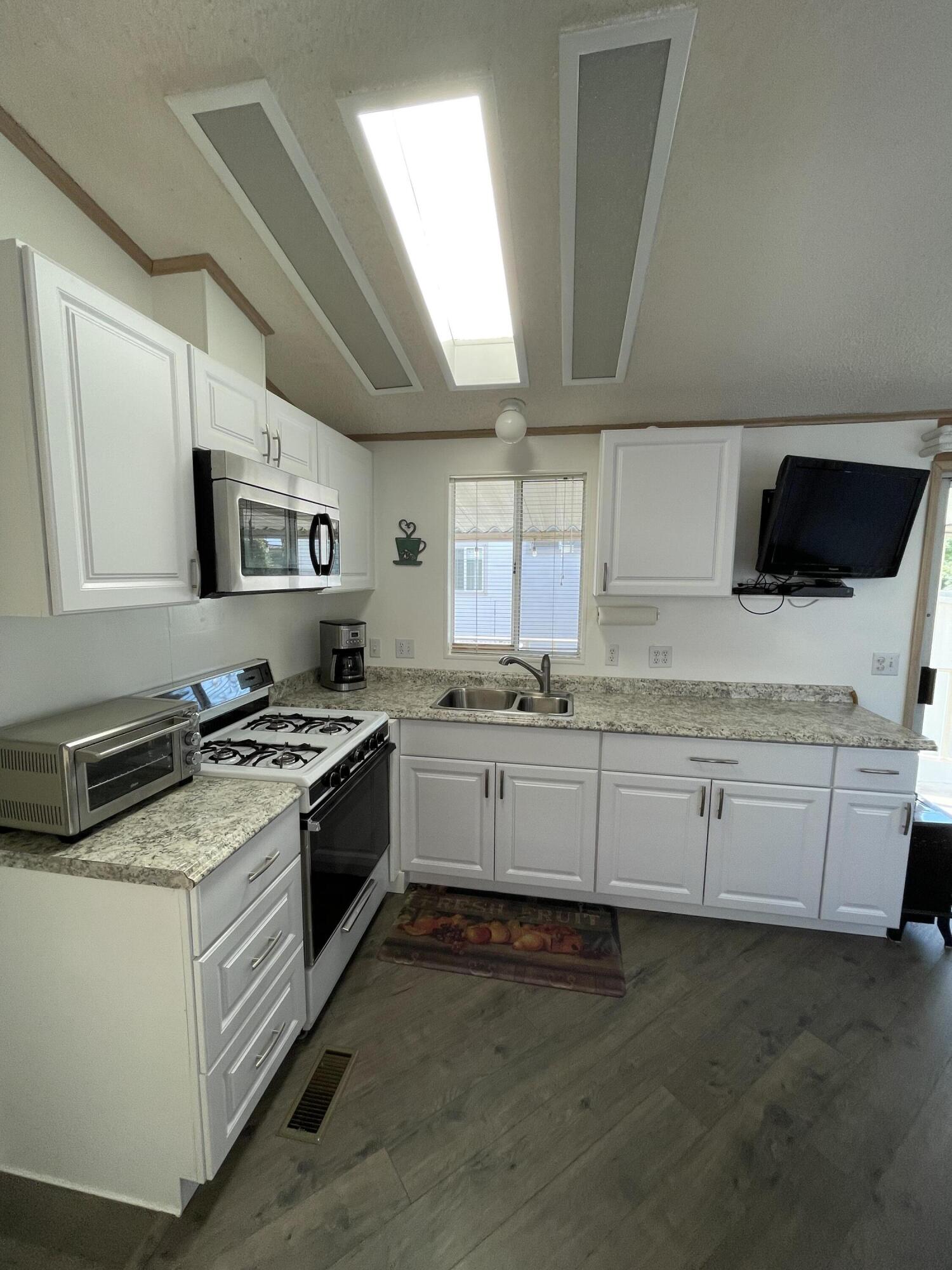 81620 Ave 49, Unit 27A Indio, CA 92201 - Photo 22 of 22 a kitchen with granite countertop white cabinets and white appliances
