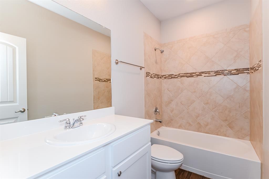 571 Kara Drive Fate, TX 75087 - Photo 13 of 16 a bathroom with a sink a toilet and a bathtub
