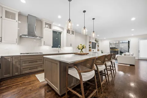 a kitchen with kitchen island a sink stove and wooden floor