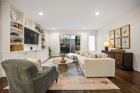 a living room with furniture a wooden floor and a large window