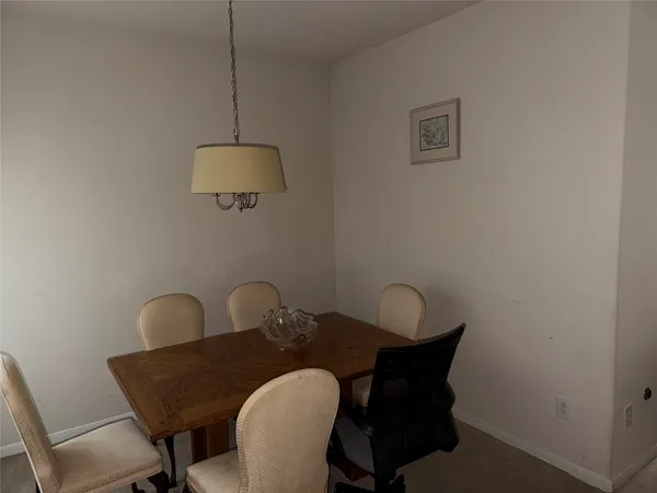 a view of a dining room and livingroom with furniture wooden floor a chandelier