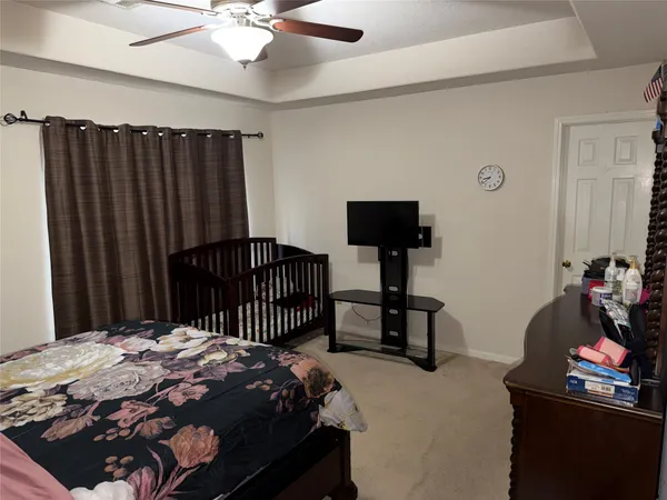 a bedroom with a bed and a flat tv screen on the dresser